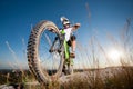 Cyclist with mountain bike on the hill under blue sky