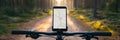 Cyclist navigating with smartphone on a forest trail during sunset Royalty Free Stock Photo