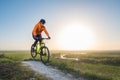 A cyclist in an orange hoodie rides a bike along a mountain path. The concept of extreme sports.