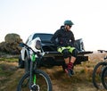 Cyclist on Pickup Off Road Truck Resting after Bike Riding in the Mountains and Talking with Friends Royalty Free Stock Photo