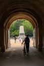 A cyclist pushes a bike through archway entrance to Horse Guards Parade