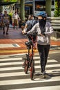 Cyclist pushing the bicycle across the zebra crossing in Chinatwon, Singapore.