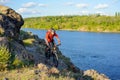 Cyclist in Red Jacket Riding Mountain Bike on the Beautiful Spring Rocky Trail above the River. Extreme Sport Concept Royalty Free Stock Photo