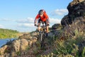 Cyclist in Red Jacket Riding Mountain Bike on the Beautiful Spring Rocky Trail above the River. Extreme Sport Concept Royalty Free Stock Photo