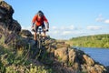 Cyclist in Red Jacket Riding Mountain Bike on the Beautiful Spring Rocky Trail above the River. Extreme Sport Concept Royalty Free Stock Photo