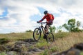 Cyclist in Red Jacket Riding Mountain Bike on the Beautiful Spring Rocky Trail. Extreme Sport Concept Royalty Free Stock Photo