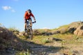Cyclist in Red Jacket Riding Mountain Bike on the Beautiful Spring Rocky Trail. Extreme Sport Concept Royalty Free Stock Photo