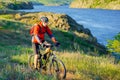 Cyclist in Red Jacket Riding Mountain Bike on the Beautiful Spring Trail above Blue River. Travel and Adventure Sport Concept Royalty Free Stock Photo