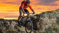Cyclist in Red Riding the Bike on Autumn Rocky Trail at Sunset. Extreme Sport and Enduro Biking Concept. Royalty Free Stock Photo