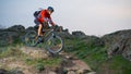 Cyclist in Red Riding the Bike on Autumn Rocky Trail at Sunset. Extreme Sport and Enduro Biking Concept. Royalty Free Stock Photo