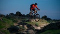 Cyclist in Red Riding the Bike on Autumn Rocky Trail at Sunset. Extreme Sport and Enduro Biking Concept. Royalty Free Stock Photo