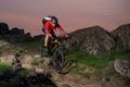 Cyclist in Red Riding the Bike on Autumn Rocky Trail at Sunset. Extreme Sport and Enduro Biking Concept. Royalty Free Stock Photo