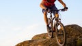 Cyclist in Red Riding the Bike Down the Rock on the Blue Sky Background. Extreme Sport and Enduro Biking Concept.