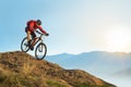 Cyclist in Red Riding the Bike Down the Rock at Sunrise. Extreme Sport and Enduro Biking Concept. Royalty Free Stock Photo