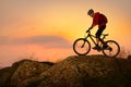 Cyclist in Red Riding Bike on the Spring Rocky Trail at Sunset. Extreme Sport and Enduro Biking Concept Royalty Free Stock Photo