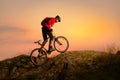 Cyclist in Red Riding Bike on the Spring Rocky Trail at Sunset. Extreme Sport and Enduro Biking Concept. Royalty Free Stock Photo