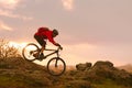 Cyclist in Red Riding Bike on the Summer Rocky Trail at Sunset. Extreme Sport and Enduro Biking Concept Royalty Free Stock Photo