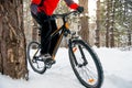 Cyclist in Red Riding Mountain Bike in Beautiful Winter Forest. Adventure, Sport and Enduro Cycling Concept. Royalty Free Stock Photo