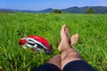 Cyclist relax on grass in mountains.