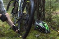 Cyclist repairs a bike in the forest.