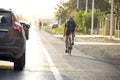 Cyclist ride bike on the road along cars passing beside him and keeping security distance with bicycles.