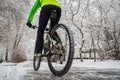 Cyclist rides in a beautiful winter park with snowy trees