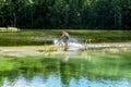 Cyclist rides a bicycle across the river at the ford Royalty Free Stock Photo