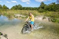 Cyclist rides a bicycle across the river at the ford Royalty Free Stock Photo