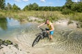 Cyclist rides a bicycle across the river at the ford Royalty Free Stock Photo