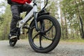cyclist rides on a bike path in the forest. Riding an electric modern bicycle. Cool fashionable bike with alloy wheels. A cyclist