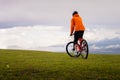 cyclist rides in the mountains among the flowering fields. Cycling tour in nature. Extreme outdoor sports. Active happy Royalty Free Stock Photo