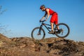 A cyclist rides over stones against a blue sky, copy of the free space. Active lifestyle, cycling