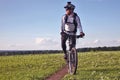 Cyclist rides on the road in a field on a bright sunny day