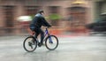 Cyclist rides through the streets on a rainy day