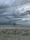 Cyclist riding on beachfront as storm rolls in over Gulf of Mexico