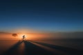 Cyclist riding bicycle creating long shadow at sunrise Royalty Free Stock Photo