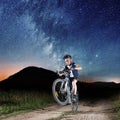 Cyclist riding bike in the night under starry sky Royalty Free Stock Photo