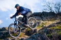 Cyclist Riding the Bike on the Rocky Trail at Sunset. Extreme Sport Concept. Space for Text. Royalty Free Stock Photo