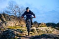 Cyclist Riding the Bike on the Rocky Trail at Sunset. Extreme Sport Concept. Space for Text. Royalty Free Stock Photo