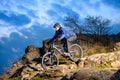 Cyclist Riding the Bike on the Rocky Trail at Sunset. Extreme Sport Concept. Space for Text. Royalty Free Stock Photo