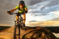 Cyclist Riding the Bike on Rocky Trail at Sunset. Extreme Sport and Enduro Biking Concept.