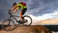 Cyclist Riding the Bike on Rocky Trail at Sunset. Extreme Sport and Enduro Biking Concept.