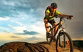 Cyclist Riding the Bike on Rocky Trail at Sunset. Extreme Sport and Enduro Biking Concept.