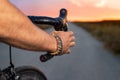 Cyclist riding a bycicle at sunset, pov view. Royalty Free Stock Photo