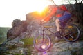 Cyclist Riding Mountain Bike Down Rocky Hill on the Spring Trail at Sunset. Extreme Sports Concept. Royalty Free Stock Photo