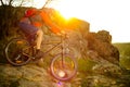 Cyclist Riding Mountain Bike Down Rocky Hill on the Spring Trail at Sunset. Extreme Sports Concept. Royalty Free Stock Photo