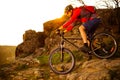 Cyclist Riding Mountain Bike Down Rocky Hill on the Spring Trail at Sunset. Extreme Sports Concept. Royalty Free Stock Photo