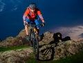 Cyclist Riding Mountain Bike Down Spring Rocky Hill at Beautiful Sunset. Extreme Sports and Adventure Concept. Royalty Free Stock Photo