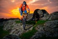 Cyclist Riding Mountain Bike Down Spring Rocky Hill at Beautiful Sunset. Extreme Sports and Adventure Concept. Royalty Free Stock Photo