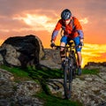 Cyclist Riding Mountain Bike Down Spring Rocky Hill at Beautiful Sunset. Extreme Sports and Adventure Concept. Royalty Free Stock Photo